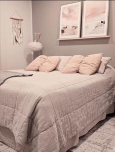 a bed with pink pillows in a bedroom at Huoneisto Olavinlinnan lähellä in Savonlinna