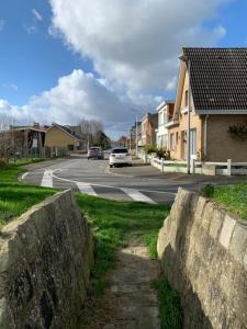 a street with a white car driving down the road at Bray-Dunes avec jardin - 3chambres in Bray-Dunes