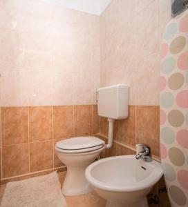 a bathroom with a toilet and a sink at Apartment Dubravka in Povljana +25 photos
