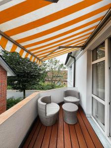 a balcony with two chairs and an umbrella at Qonroom - as individual as you - Wulferdingsen in Bad Oeynhausen