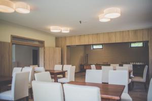 a dining room with white chairs and tables at Diás Panzió in Orfű
