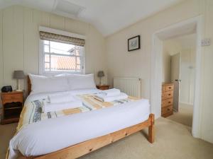 En eller flere senge i et værelse på Iona Cottage