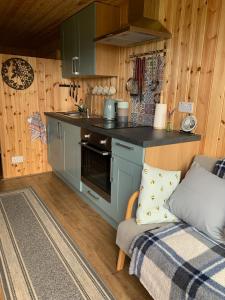 a kitchen with a stove and a couch in a room at The Lookout in Padstow