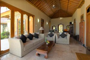 a living room with couches and a coffee table at Villa Rama in Candidasa