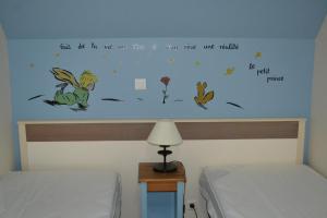 a bedroom with two beds and a wall with words at La Maison Rose in Fort-Mahon-Plage +38 photos