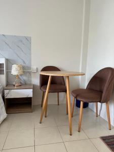 カタビーチにあるApartments Kata Beach view gardenのテーブルと椅子2脚、ランプが備わります。
