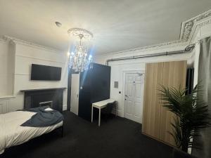 a bedroom with a bed and a chandelier at Fulforth St Studio Apartments in Nottingham