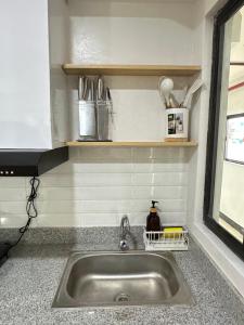 a kitchen counter with a sink and a window at Tiffany's Place in Imus +22 photos