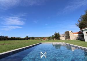 a swimming pool with a m sign in a yard at MyStay - Quinta das Aromáticas in Malta