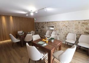 a dining room with white chairs and a wooden table at MyStay - Quinta das Aromáticas in Malta +84 photos