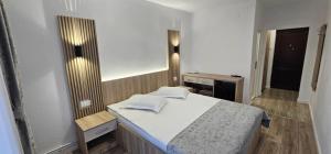 a small bedroom with a bed and a mirror at Motel Cristina in Bicaz