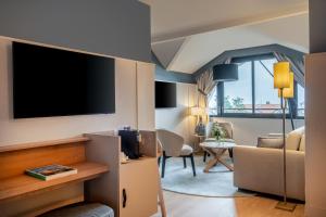 TV a/nebo společenská místnost v ubytování Hôtel Arcanse by Inwood Hotels