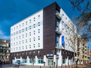a large white building on a city street at ibis budget Issy Les Moulineaux Paris Ouest in Issy-les-Moulineaux