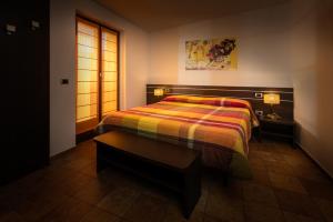 A bed or beds in a room at Al Fogolâr Rooms & Osteria with Saunaland
