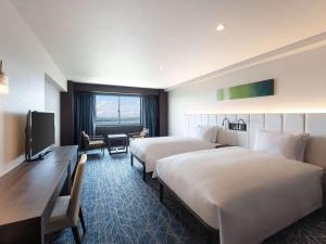 a hotel room with two beds and a television at Grand Mercure Lake Hamana Resort & Spa in Hamamatsu