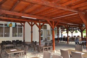 an outdoor patio with tables and chairs and a building at Motel Cristina in Bicaz +33 photos