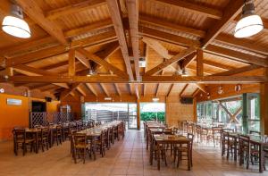 a dining room with tables and chairs in a building at Club del Sole Rivaverde Easy Camping Village in Marina di Ravenna