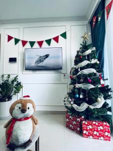 a christmas tree in a living room with a stuffed animal next to a table at An homestay, apartment Nera Huế in Thôn Văn Dương