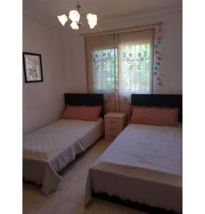 une chambre avec deux lits et une fenêtre dans l'établissement Preciosa casa con terraza y piscina R106 by Novadesta, à Puerto Marino