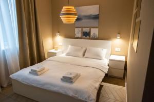 a bedroom with a bed with two towels on it at Lovcevic Apartmani & Sobe in Šabac +35 photos