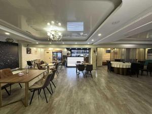 a restaurant with tables and chairs in a room at Erkhes hotel in Dalandzadgad