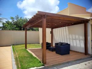 a wooden pergola with a couch on a deck at Dunas residence casa 04 in Santo Amaro