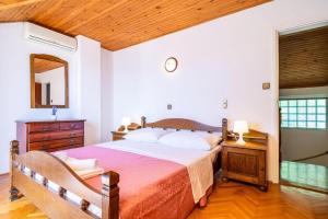 Un dormitorio con una cama grande y un espejo. en Three Bedroom Villa surrounded by Nature with Pool, en Gruda 25 fotos más