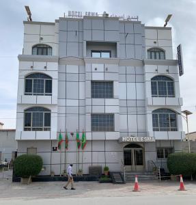 努瓦迪布Hôtel Esma Nouadhibou的一个人在旅馆大楼前行走