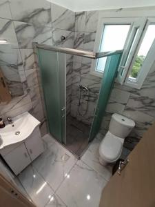 a bathroom with a toilet and a sink and a shower at Chios Cozy Apartment 3 in Sklaviá +27 photos