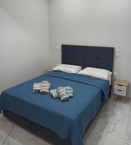 a blue bed with two towels on top of it at Chios Cozy Apartment 3 in Sklaviá