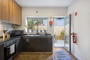 eine Küche mit Spüle und Mikrowelle in der Unterkunft Jm Stay Aveiro in Aveiro + 23 Fotos