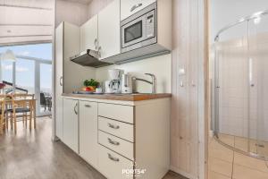 a kitchen with a sink and a microwave at Ferienhaus Bergwiesenblick - Sankt Andreasberg im Harz in Sankt Andreasberg +19 photos