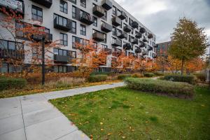 an apartment building with a lawn in front of it at miniSTUDIOS URSUS by VAYA STAYS in Warsaw
