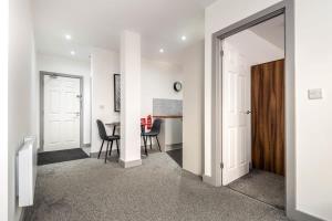 a hallway with a dining room and a table with chairs at Bright & Cosy Apartment in Leeds! Free Parking in Belle Isle