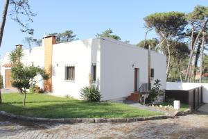 a white house with a courtyard at Bonança Dunas Village in Fão