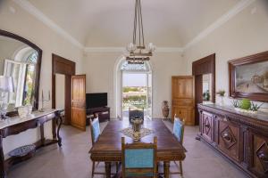 a dining room with a wooden table and a large window at 4 Bedroom Villa, Private Pool, Marsala in Marsala