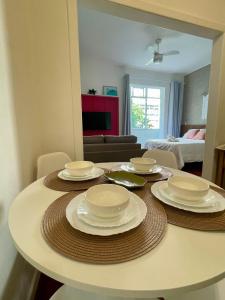 a table with plates on it in a living room at Loft espaçoso a 300m da praia in Rio de Janeiro