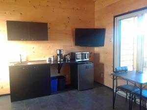 a kitchen with a counter and a table with a microwave at #1 Le refuge et #2 Le Gite in Saint-Onésime