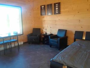 a bedroom with two chairs and a bed and a desk at #1 Le refuge et #2 Le Gite in Saint-Onésime