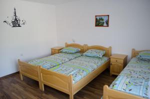 two beds in a room with white walls and wooden floors at Morski Rai Apartments in Byala
