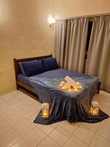 a bedroom with a bed with candles on it at Seaput Homes in Ayer Itam
