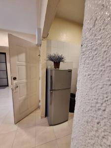 a kitchen with a refrigerator and a door with a plant on it at Seaput Homes in Ayer Itam