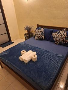 a bed with two towels on top of it at Seaput Homes in Ayer Itam
