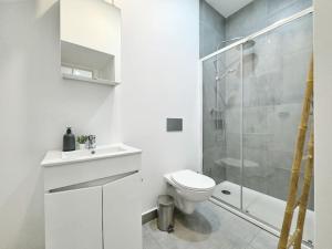 un bagno bianco con wc e doccia di Minimalist Studio with Mezzanine a Lisbona Altre 9 foto