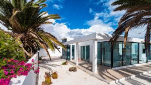 a house on the beach with palm trees at Casa Marina in Costa Teguise