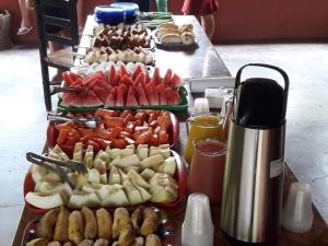 a table with several trays of different types of food at Balneário Rio Agua Viva - Área de Camping in Areia +6 photos