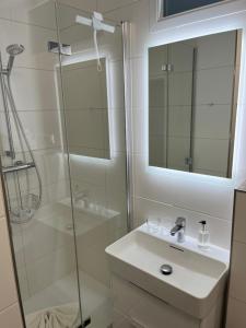a bathroom with a shower and a sink and a mirror at Sander's Höft Appartments - Direkt am Strandaufgang in Juist +28 photos