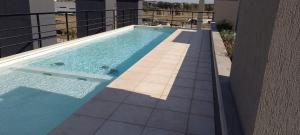 a swimming pool on the side of a building at Dpto Jacarandá in Sunchales