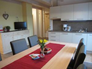eine Küche mit einem Tisch und einer Blumenvase darauf in der Unterkunft Liebharterhof in Olang