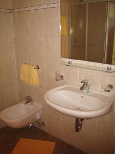 ein Bad mit einem Waschbecken und einem Spiegel in der Unterkunft Liebharterhof in Olang
